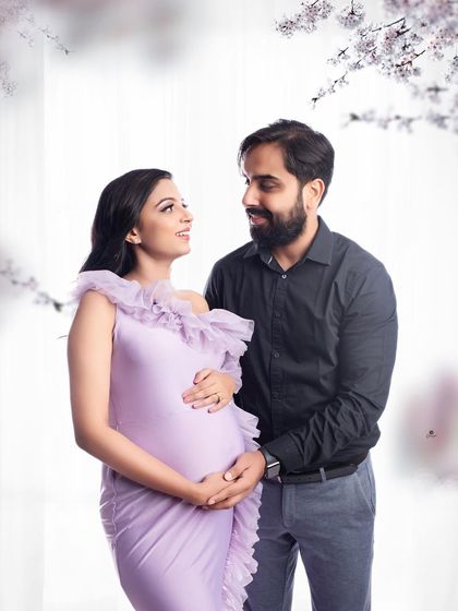 A tender moment between partners, framed by soft floral elements. The lavender gown adds a touch of spring-like romance to this sweet and intimate couple's portrait.