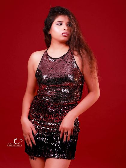 A classic standing pose that is both elegant and powerful. The red background makes the black sequins stand out beautifully.