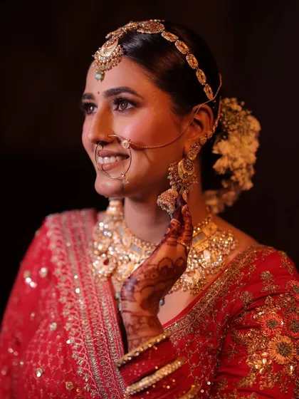 Prakriti looked absolutely divine in her red bridal lehenga. We paired it with traditional gold jewelry and a makeup look that was both classic and radiant, finished with a floral bun.