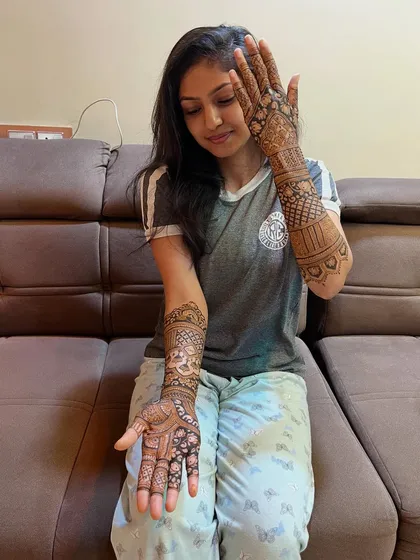 A beautiful mehendi design for a special occasion. The client is happily showing off her intricate henna, a mix of traditional and modern styles.
