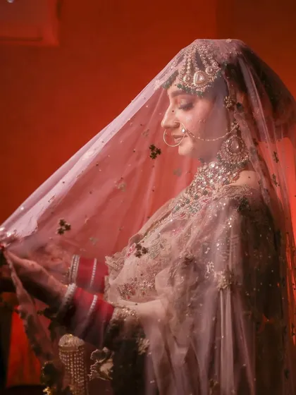 A beautiful shot of the bride under her veil, creating a soft, romantic, and traditional bridal portrait.