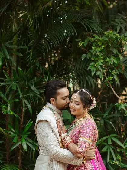 An intimate embrace against a lush green backdrop. These natural, serene settings provide a beautiful contrast for couple portraits.