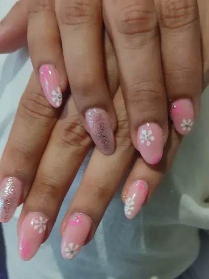 A sweet and delicate design on almond-shaped nails. I used a soft pink base, a glitter accent nail, and hand-painted small white flowers for a fresh, spring-inspired manicure.