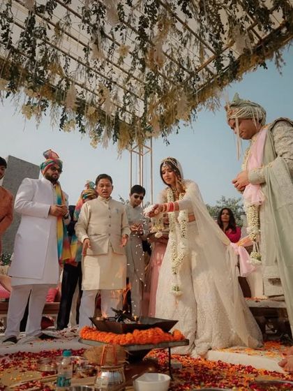 The couple performs a ritual together at the sacred fire, a key moment of participation and partnership in the Hindu wedding ceremony.