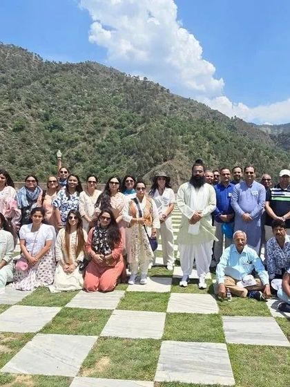 A group photograph from our Himachal retreat, taken in a beautiful location with a checkered green lawn and mountain views. These moments of togetherness are a cherished part of the journey.