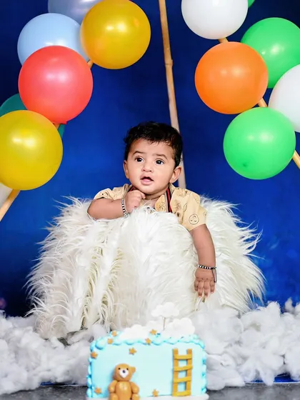 Up, up, and away! This hot air balloon theme is a whimsical and adorable concept for a first birthday shoot. The fluffy clouds, colourful balloons, and cute cake make for a magical setting.