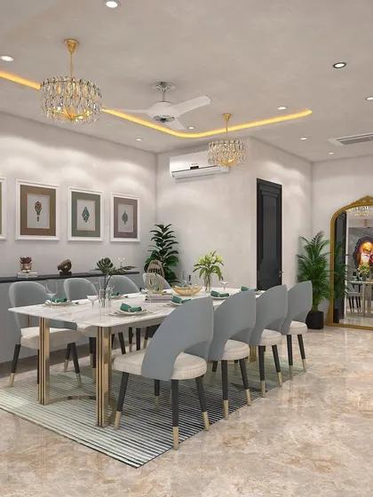 A bright and elegant dining area reveal. The space features a marble-topped table, light grey chairs, twin crystal chandeliers, and a large gilded mirror to amplify light and add a touch of glamour.