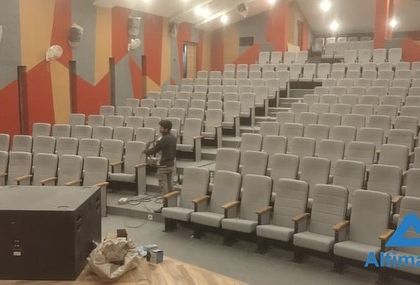 An engineer works on the final connections for the stage's audio system. This phase is critical for ensuring all sound equipment, from microphones to subwoofers, is perfectly integrated and calibrated for the room's acoustics.