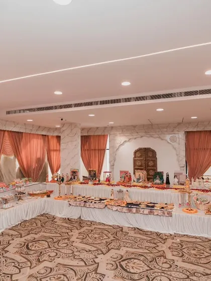 We can transform an entire hall into a festive wonderland. This wide view shows the scale of a grand baby shower setup, with multiple tables for `rukhwat`, food, and gifts, all tied together beautifully.