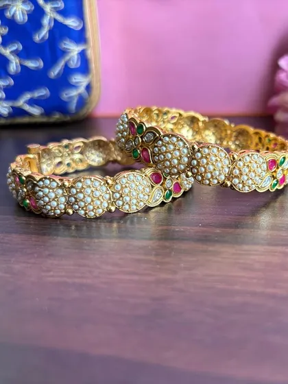 A close-up of the pearl cluster bangles, showing the intricate floral stone work.
