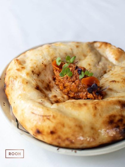 Another look at our Smoked Butter Chicken Kulcha, a crowd-pleaser from our à la carte menu. The generous filling is what makes this dish so special.