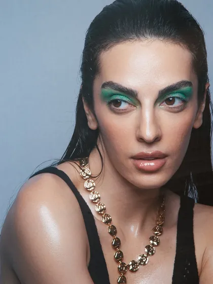 A close-up on the bold green eyeshadow, balanced with a fresh, dewy skin finish.