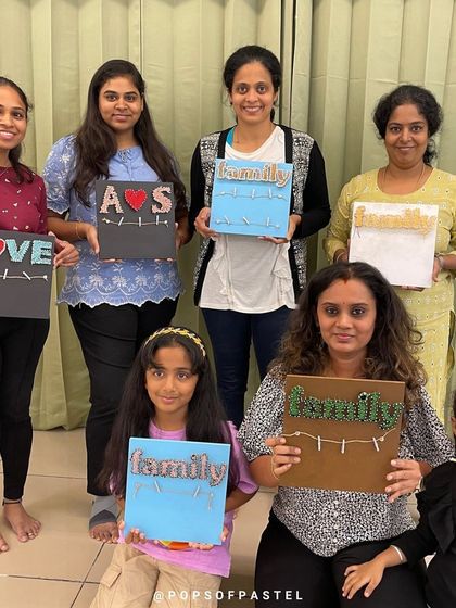 The whole group from our string art workshop posing with their finished creations. It's wonderful to see so many unique designs.