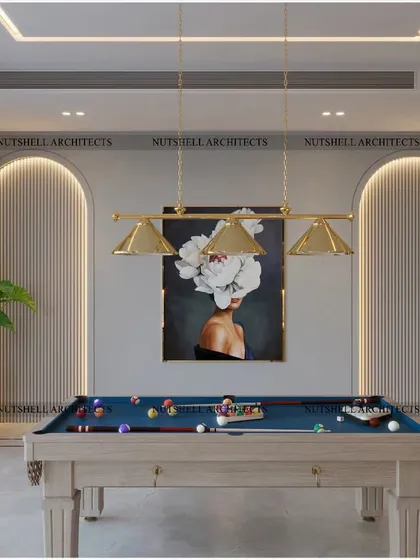 An elegant and minimalist entertainment lounge featuring a classic pool table. The back wall is adorned with arched panels and backlighting, creating a sophisticated ambiance, while a piece of modern art adds a pop of color.