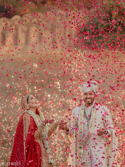 This is the kind of explosive joy I live to capture. Amruta and Jigar, surrounded by a storm of petals and fireworks against a historic fort. This single moment encapsulates the energy and scale of a grand Indian wedding, a celebration of love that is both powerful and beautiful.