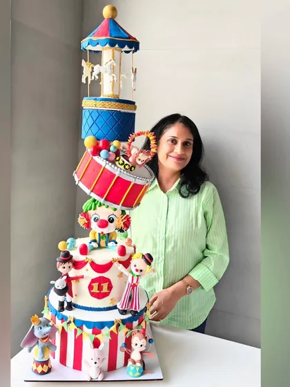 My most ambitious project: a topsy-turvy carnival-themed cake. This multi-tier, structured cake features a rotating carousel, a slanted drum tier, and dozens of handcrafted fondant circus characters.