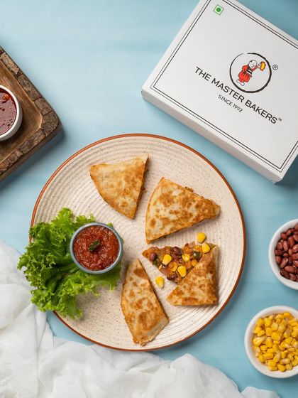 Our Mexican Quesadillas are filled with cheese, beans, corn, and spices, then grilled until the tortilla is golden brown and the cheese is perfectly melted. Served with a side of salsa.