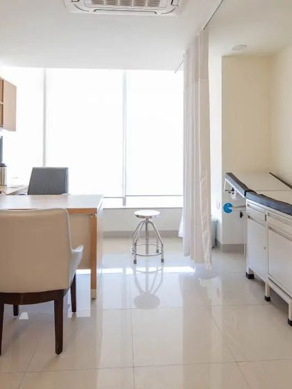 A consultation room designed with clean lines, ample natural light, and an uncluttered layout. This environment is intended to be calming and professional, facilitating clear communication between doctors and patients.