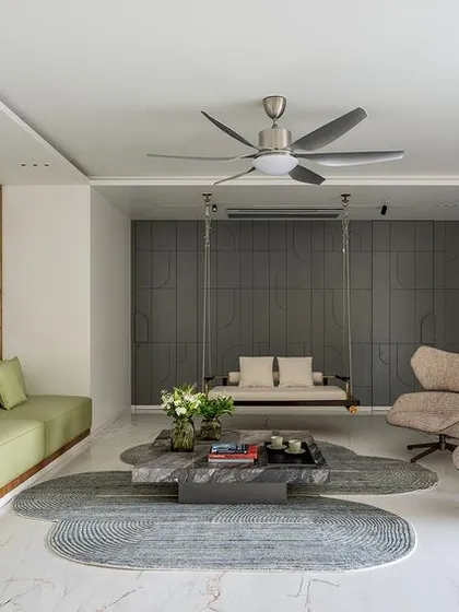This formal living space from my Park West project embodies my design philosophy of creating tranquil, sophisticated environments. I used a layered neutral palette, punctuated by the soft green of the sofa and the warmth of a custom brass partition, to create distinct zones that flow into one another. The indoor swing adds a touch of playful serenity, making the space feel both grand and intimately personal.