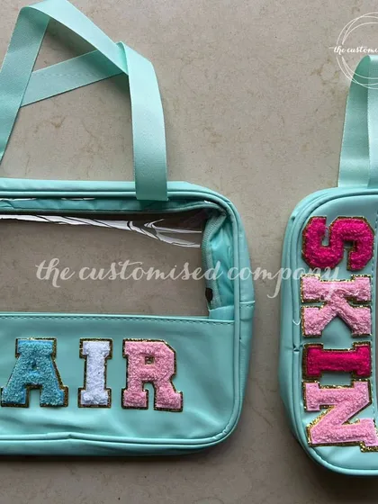 A pouch for every mood is just good planning. This set of clear, mint-colored pouches is customized with "HAIR" and "SKIN" in colorful patches, helping you keep your beauty products perfectly organized.