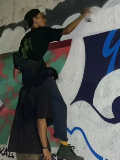 Getting a little help from a friend to reach the top of a wall. Teamwork is essential in street art, whether it's for a big commission or a fun night session.