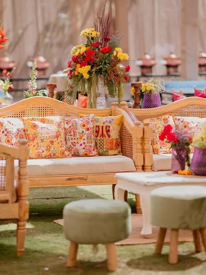 Another beautiful lounge setup from the 'Rajasthani Folklore' Mehendi, featuring cane furniture and vibrant, printed cushions.