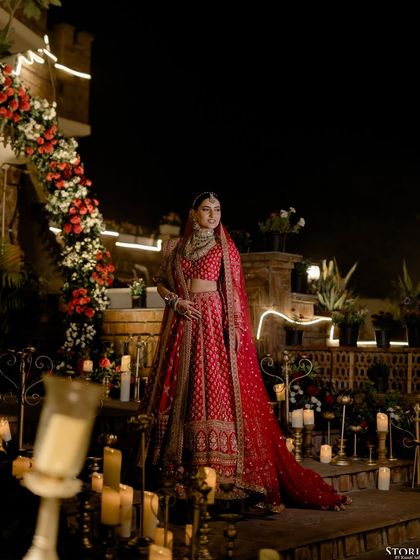 A stunning solo portrait of the bride, Kajal, surrounded by candles, creating a warm and romantic ambiance for her night wedding.