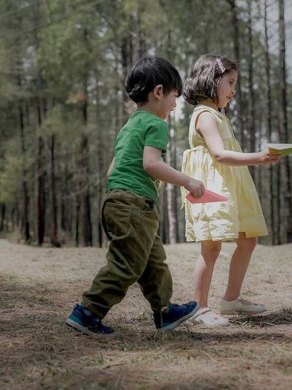 Siblings walking together through a forest path, creating a sense of adventure and companionship.
