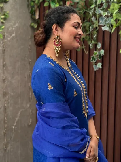 A side profile showcasing the elegant bun hairstyle and statement earrings.
