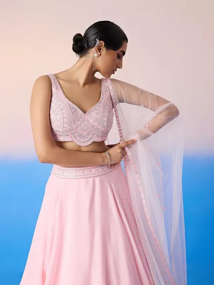 A closer look at the embellished V-neck blouse of the pink lehenga, showcasing the intricate beadwork.