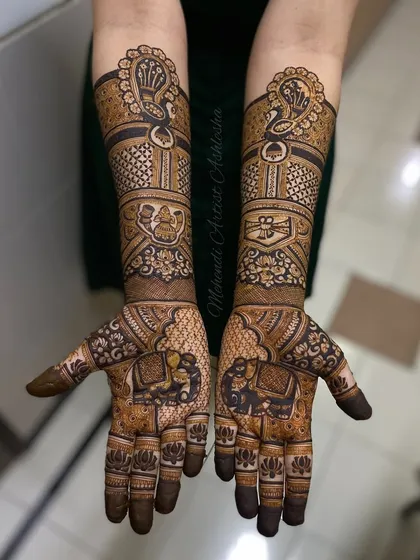 This bridal design is filled with traditional symbols. One arm features a peacock and kalash, while the other has a dholak and shehnai, celebrating the music and rituals of a wedding.