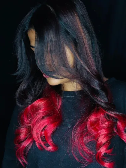 We encourage our students to explore their creativity with bold hair color. This vibrant red ombre look, created during a student hair lab, showcases advanced color application and blending skills for a stunning, head-turning result.