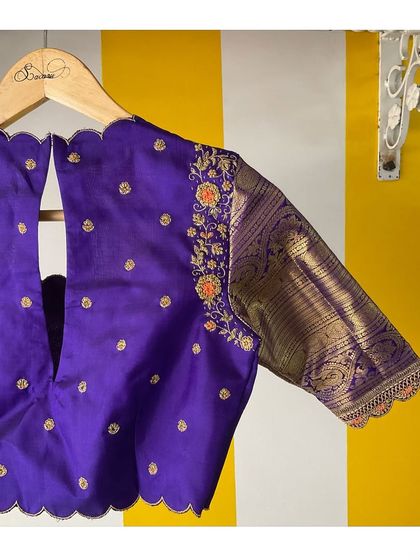 The back of our purple Kanjeevaram blouse, showing the scalloped V-neck cutout and the beautiful contrast of the woven brocade sleeve.