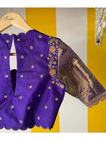The back of our purple Kanjeevaram blouse, showing the scalloped V-neck cutout and the beautiful contrast of the woven brocade sleeve.