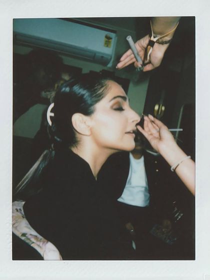 A candid polaroid of Sonam Kapoor in the makeup chair, getting ready for her shoot in the Rimzim Dadu metal saree.