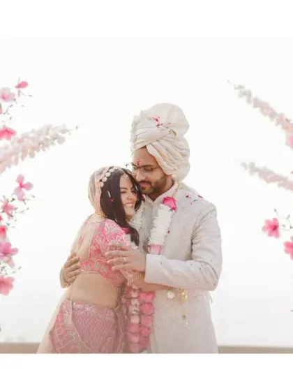 A warm embrace after the wedding ceremony. Framed by beautiful pink and white flowers, this shot is filled with the joy and relief of finally being married.