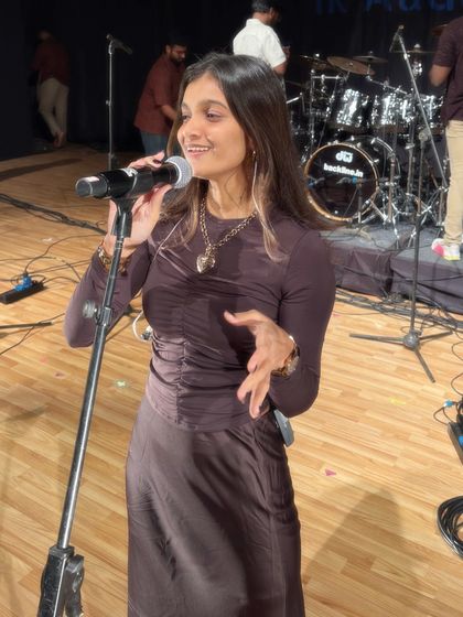 A candid moment of me interacting with the audience during a live show, with my band in the background.