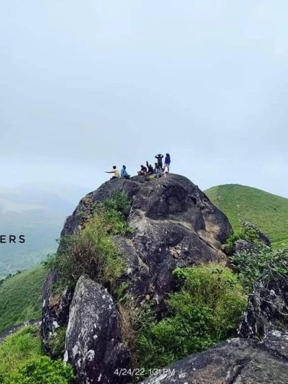 A group of our adventurers relaxing on a rock at the summit, taking in the stunning views.