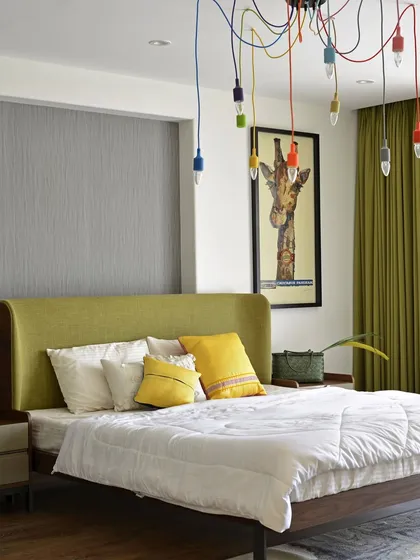 A cozy oasis where muted shades of sophistication reign. The real star in this Pune showflat bedroom is the statement hanging lights, bursting with bright colors and retro vibes, adding a touch of whimsical fun.