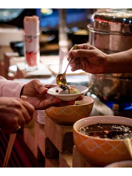 A close-up of a guest being served at our live station, showcasing the variety of toppings and sauces available.
