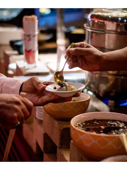 A close-up of a guest being served at our live station, showcasing the variety of toppings and sauces available.