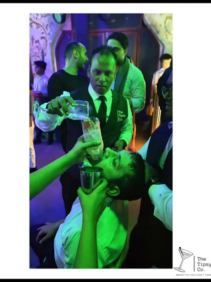 A guest enjoying a drink poured directly from the bottle by our skilled bartender. It's a classic party move that always gets a great reaction.