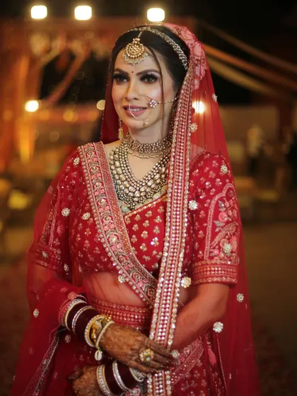 A full-length view of the bride, looking elegant and poised. The jewellery completes her timeless look.