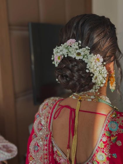 Another angle of the braided floral bun, showing how the flowers are woven into the hair for a natural, garden-like effect.