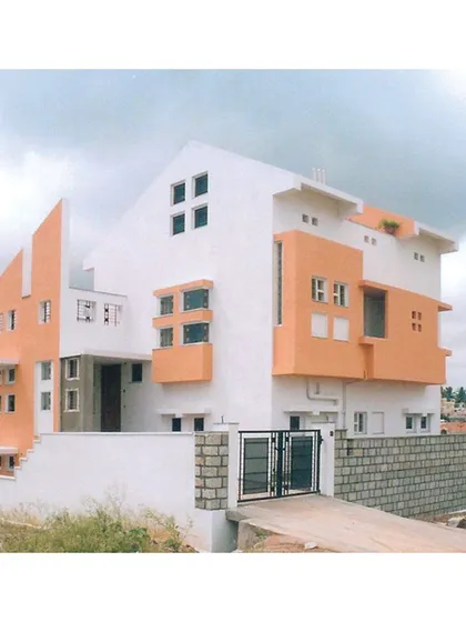 The front elevation of 'Nachiar Illam', demonstrating how the structure is grounded on its site while projecting a modern and clean aesthetic.