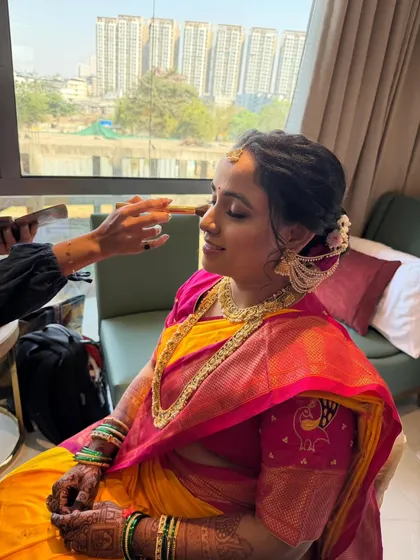 Here is a behind-the-scenes moment, applying finishing touches to a serene Maharashtrian bride. The mandap look was designed to be long-lasting and comfortable, with a focus on enhancing her features for a gentle, intentional, and graceful appearance.