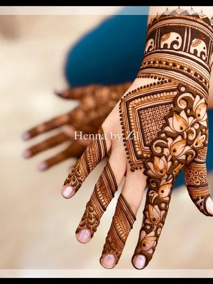 A beautiful back-hand design with lotus and elephant motifs, showing how the pattern wraps around the fingers.