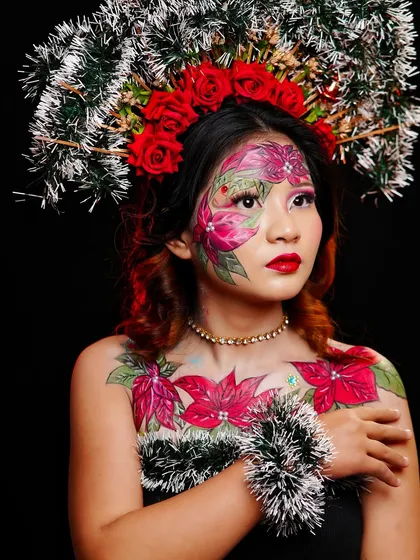 A profile view of the Christmas look, highlighting the intricate details of the headpiece and the body art.