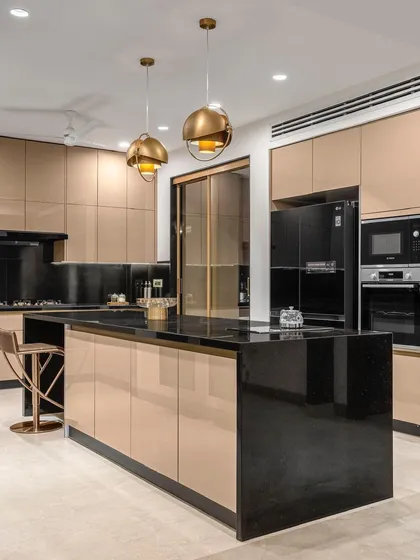An alternate view of the kitchen highlights the expansive island with an integrated breakfast counter. The sleek, handleless cabinets and built-in appliances maintain a clean, monolithic look that is both practical and visually impressive.