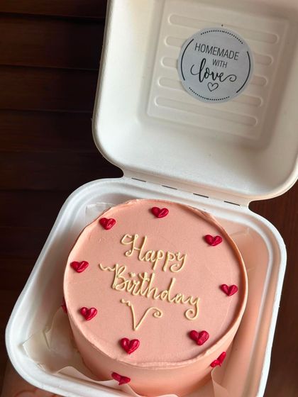 A lovely peach-colored bento cake with a simple birthday message and tiny red hearts. It’s a classic design that’s always in style.